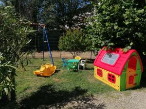 uma área recreativa para crianças com uma casa de brinquedos e um baloiço em Agriturismo Il Vecchio Portico em Francavilla Bisio