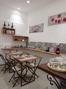 una cucina con tavoli e sedie in una stanza di B&B Cuore Barocco a Ragusa