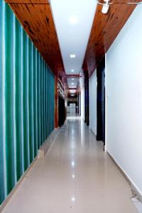 a long hallway with a green and white wall at Balaji Hotel in Ahmedabad