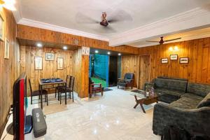 a living room with a couch and a table at 4bhk cabin in the woods- Lonavala in Lonavala