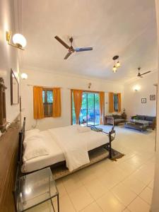 羅納瓦拉的住宿－4bhk cabin in the woods- Lonavala，一间卧室配有一张床和吊扇