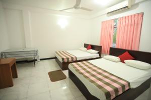 a bedroom with two beds and a window at Pleasure Island Holiday Home in Dambulla