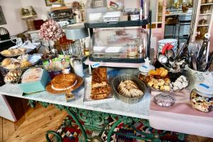 une table remplie de nombreux types de denrées alimentaires différents dans l'établissement Maison Garnier Hôtel de Charme Biarritz, à Biarritz