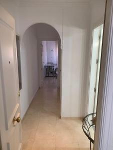 a hallway with an archway in a white room at Apartamento, Piccolo Mare, junto centro, vistas Sierra Nevada in Granada