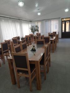 a dining room with wooden tables and chairs at Pensiunea Beatrice in Sovata