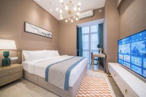 1 dormitorio con 1 cama grande y TV de pantalla plana en Gepai Executive Apartment - Shenzhen Futian Convention and Exhibition Center, en Shenzhen