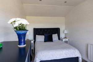 a bedroom with a bed with a blue vase with flowers at doolinyoga luxury accommodation in Doolin