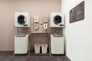 a room with two washing machines and a washer at Kiwi Express Hotel - Zhongqing in Taichung