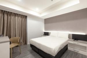 Habitación de hotel con cama y escritorio en Kiwi Express Hotel - Zhongqing, en Taichung