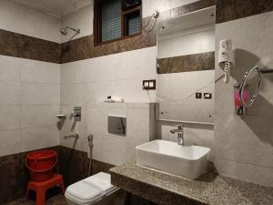 y baño con lavabo, aseo y espejo. en King Castle fully ac hotel Near Mall Road, en Dharamshala