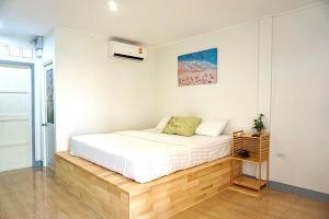 a bedroom with a white bed and a window at The kn kohlarn resort in Ko Larn