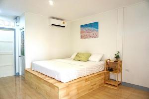 um quarto com uma cama branca e uma janela em The kn kohlarn resort em Ko Larn