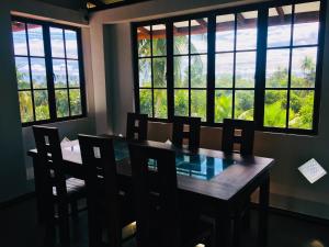 ディックウェラにあるMount House Hotel Apartmentのテーブルと椅子と窓のあるダイニングルーム