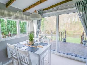 uma sala de jantar com uma mesa branca e uma grande janela em Riverside Rest em Builth Wells