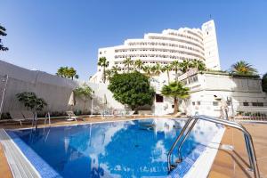 a large swimming pool in front of a building at THE WHITE CORNER BY HOMESTAYGRANCANARIA in San Bartolomé de Tirajana