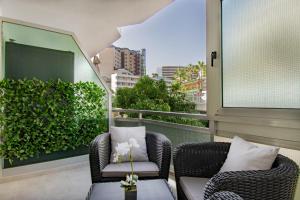 d'un balcon avec deux chaises et une table. dans l'établissement THE WHITE CORNER BY HOMESTAYGRANCANARIA, à San Bartolomé