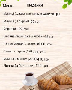 a menu with a plate of croissants and a cup of coffee at Villa Paraiso Karpaty in Tesnyts'ka