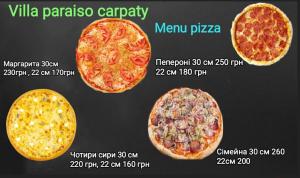 three pizzas with different toppings on a table at Villa Paraiso Karpaty in Tesnyts'ka
