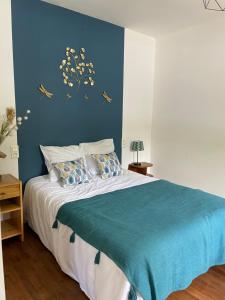 a bedroom with a bed with a blue wall at Maison gîte 2/4 P baie du mont in Pontorson