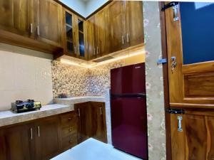a kitchen with wooden cabinets and a red refrigerator at DMoon Villa in Yogyakarta +13 photos