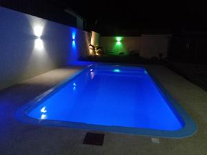 niebieski basen w domu w nocy w obiekcie The Starlight w mieście Grande Rivière Sud Est