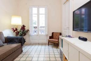 a living room with a couch and a flat screen tv at Cal Mateu 11 huéspedes Sagrada Família in Barcelona