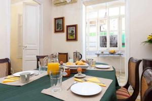 uma mesa de jantar com uma toalha de mesa verde e uma toalha de mesa verde em Cal Mateu 11 huéspedes Sagrada Família em Barcelona