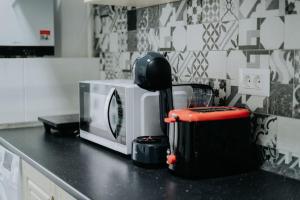 a microwave sitting on a kitchen counter with a suitcase at Plaza View in Bucharest
