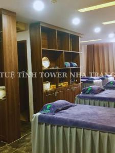 a room with two beds and a cabinet at Tuệ Tĩnh Tower in Nha Trang