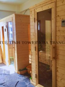 a wooden house with a glass door in a room at Tuệ Tĩnh Tower in Nha Trang