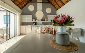 a kitchen with a table with a vase of flowers at CANAL GUEST HOUSE - Waterfront Boutique B&B in St Francis Bay