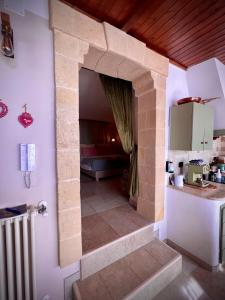 eine Küche mit einer Theke und ein Zimmer mit einem Herd in der Unterkunft Le Dimore in Piazzetta in Massafra