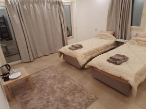1 dormitorio con 2 camas, mesa y espejo en Fantastic new rooms close to New Cairo Festival City and airport en El Cairo
