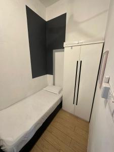 a small room with a bed and a refrigerator at SW Rental in Penampang