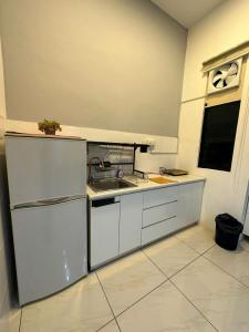 una cocina con armarios blancos y fregadero en SW Rental, en Penampang