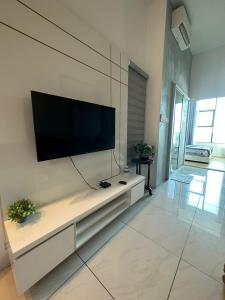a living room with a flat screen tv on a wall at SW Rental in Penampang