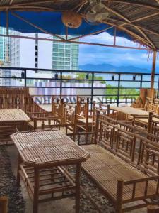 an empty restaurant with wooden tables and chairs at Tuệ Tĩnh Tower in Nha Trang