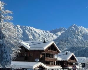 un lodge de esquí con montañas cubiertas de nieve en el fondo en Ferienwohnung Maringga, en Obermaiselstein