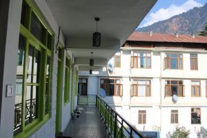 een lege hal van een gebouw met groene ramen bij Trippy Turtle Hostel in Manāli