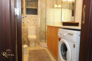 a bathroom with a toilet and a washing machine at Royal Luxury Amman Central Apartmetns in Amman