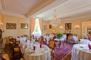 a dining room with white tables and chairs and a chandelier at Château de la Verie in Challans +41 photos