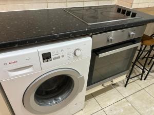 a white washing machine in a kitchen with a counter at Room137 Stay in Stoke Newington in London