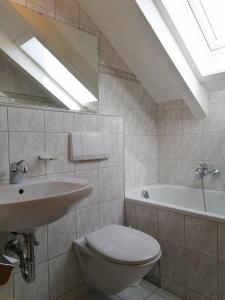 een badkamer met een toilet, een wastafel en een bad bij Appartement Köll in Sölden