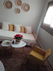 a living room with a couch and a table and a chair at Studio 'Katerina by the Sea' in Salamina