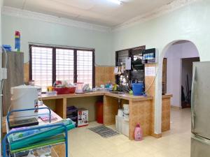 a kitchen with a counter and a refrigerator at Family's Homestay in Kuala Terengganu