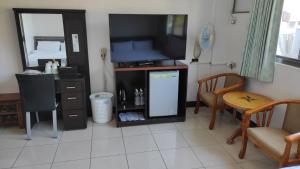 a living room with a flat screen tv and a small refrigerator at 宏嶺溫泉山莊 in Baihe