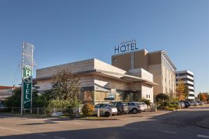 a hotel with cars parked in a parking lot at Noventa Hotel in Noventa di Piave