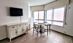 SANXENXO , apartamento nuevo 300 mts playa Silgar في سانكسينكسو: غرفة مع طاولة وتلفزيون في غرفة