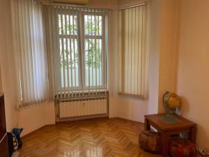 ein Wohnzimmer mit zwei großen Fenstern und Holzboden in der Unterkunft Casa del Rey in Sofia