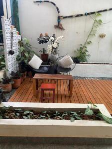 un patio avec une table, un banc et des plantes dans l'établissement Flower Home ផ្ទះសំណាក់ ហូមផ្កា, à Sihanoukville